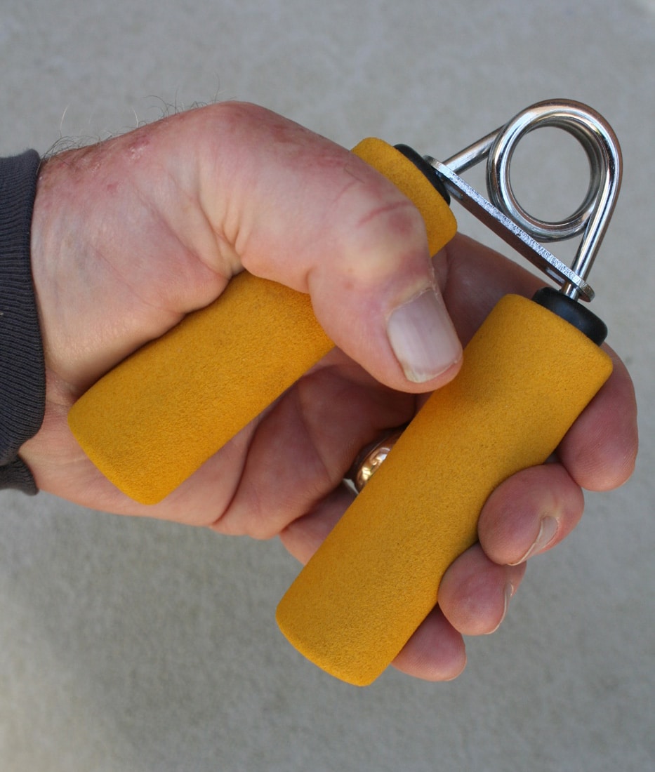 This photograph shows an older man using a hand exercise tool to build grip strength and enhance his shooting skills. It emphasizes the importance of physical conditioning for senior citizens engaged in shooting sports and target shooting at the firing range. The man’s focused workout is a vital part of active shooter training and proper handgun control. This image highlights how overcoming challenges such as arthritis and reduced motor skills can improve overall firearm handling. The exercise routine supports self defense by ensuring better accuracy and trigger control when using a pistol or handgun.